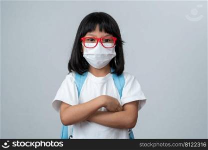 Portrait of Asian girl kid with protective face mask and school backpack ready for new school year with pandemic restrictions. Concept of kid going back to school and new normal lifestyle