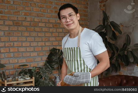 Portrait of Asian handsome man cooking in kitchen room at home. Lifestyle Concept.