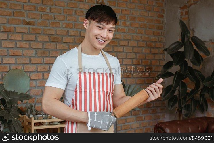 Portrait of Asian handsome man cooking in kitchen room at home. Lifestyle Concept.