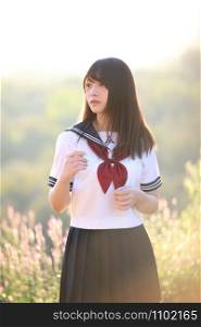 Portrait of asian japanese school girl costume looking at park outdoor in sunrise