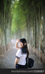 Portrait of asian japanese school girl costume looking in bamboo grove