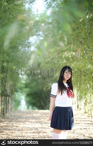 Portrait of asian japanese school girl costume looking in bamboo grove