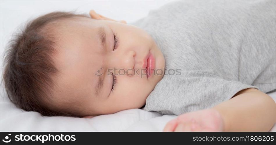 Portrait of asian little baby girl sleeping on bed in the bedroom at home, newborn napping with cozy and relax, infant innocence in bedtime, happy toddler cute, growth of child and emotion, indoors.