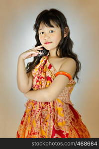 Portrait of asian little girl in orange dress. portrait of asian little girl