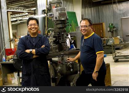 Portrait of Asian machinists in work shop.