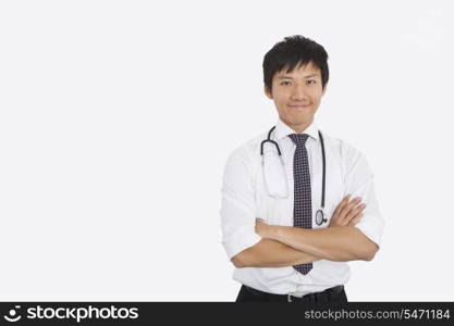 Portrait of Asian male doctor with arms crossed over white background