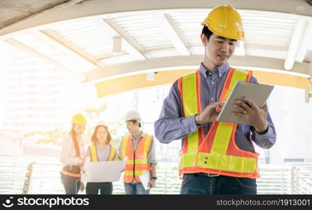 Portrait of Asian male engineer holding tablet and working on civil site project. Engineering Concept.