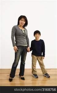 Portrait of Asian mother and son holding hands.