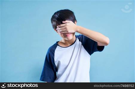 Portrait of Asian teenage boy covered his eyes with his hand in studio