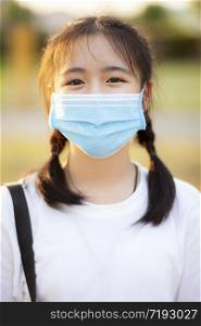 portrait of asian teenager wearing protection mask standing outdoor