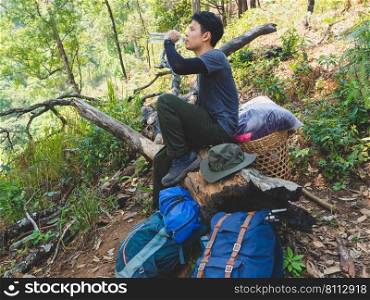 Portrait of Asian traveler man with backpack on a hiking trip in forest.