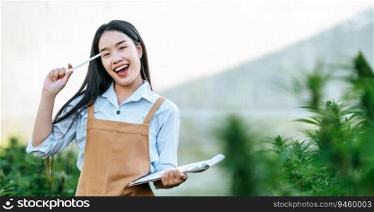 Portrait of Asian woman marijuana researcher thinking in cannabis farm, Business agricultural cannabis. Cannabis business and alternative medicine concept.