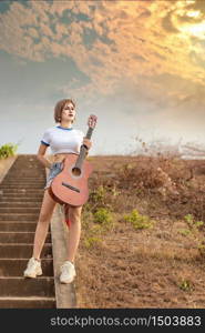 portrait of asian woman with guitar in nature. asian woman with guitar