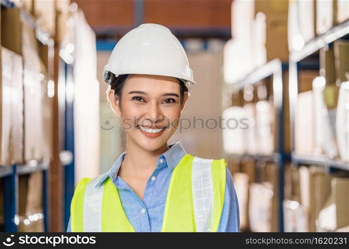 Portrait of Asian woman worker with safety clothes into local warehouse again after covid19 outbreak, business and export industry concept