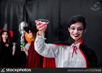 Portrait of asian young adult teenage man wear Halloween costume cloth with group of friends in Halloween party background. Halloween celebrate and international holiday concept.