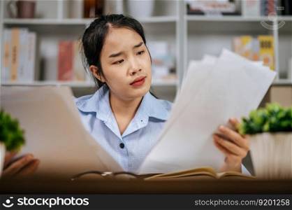 Portrait of asian young woman freelancer working with papers at workplace at home office, during quarantine covid-19 self isolation at home, work from home concept