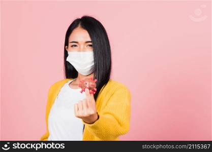Portrait of Asian young woman wear face mask protective holding DNA strand of Coronavirus (COVID-19, 2019-ncov) genetic instruction, new strain RNA mutation, studio shot isolated on pink background
