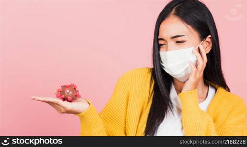 Portrait of Asian young woman wear face mask protective holding DNA strand of Coronavirus (COVID-19, 2019-ncov) genetic instruction, new strain RNA mutation, studio shot isolated on pink background