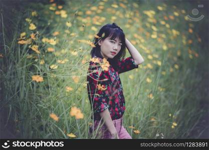 portrait of asian younger woman model pose in yellow flower blooming field