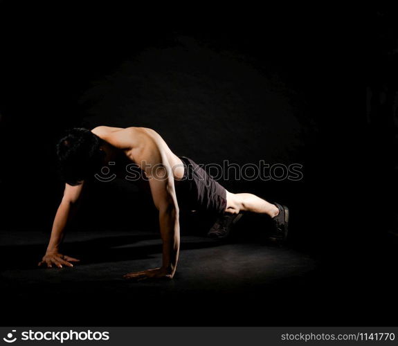 portrait of athletic muscular bodybuilder man with naked torso doing push ups exercise. fitness workout concept