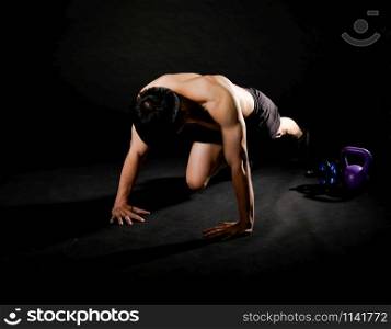 portrait of athletic muscular bodybuilder man with naked torso doing push ups exercise. fitness workout concept