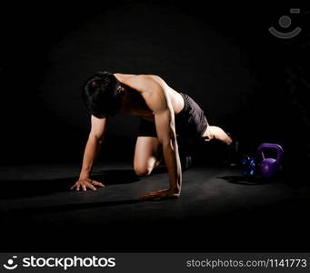 portrait of athletic muscular bodybuilder man with naked torso doing push ups exercise. fitness workout concept