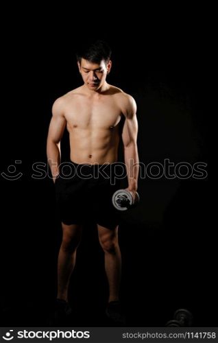 portrait of athletic muscular bodybuilder man with naked torso six pack abs working out with dumbbell. fitness sport exercise concept
