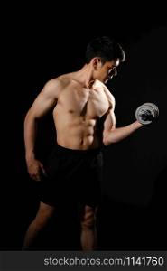 portrait of athletic muscular bodybuilder man with naked torso six pack abs working out with dumbbell. fitness sport exercise concept