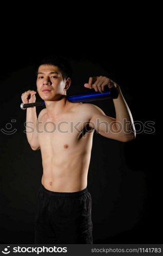 portrait of athletic muscular bodybuilder man with naked torso six pack abs holding baseball bat. fitness workout concept