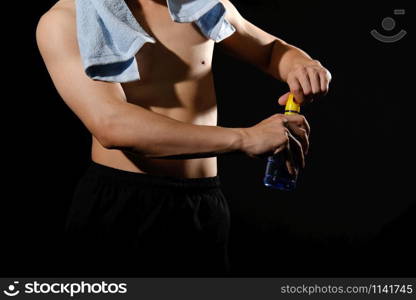 portrait of athletic muscular bodybuilder man with naked torso six pack abs holding water bottle. fitness workout concept