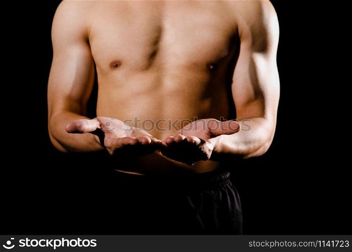 portrait of athletic muscular bodybuilder man with naked torso six pack abs showing copy space. fitness workout concept