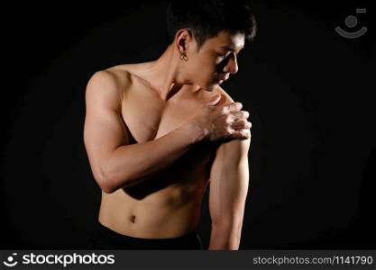 portrait of athletic muscular bodybuilder man with shoulder pain. fitness workout injury concept