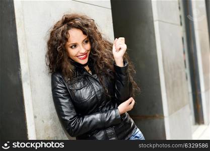 Portrait of attractive black woman in urban background wearing leather jacket