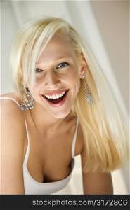 Portrait of attractive blonde Caucasian young adult woman smiling and looking at viewer.