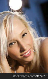 Portrait of attractive blonde Caucasian young adult woman smiling and looking at viewer.