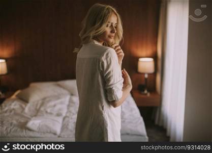 Portrait of attractive blonde woman by window