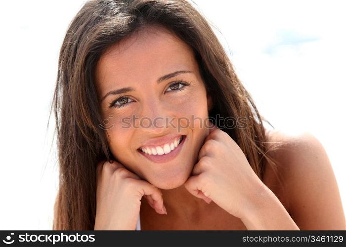 Portrait of attractive brunette laying on a beach