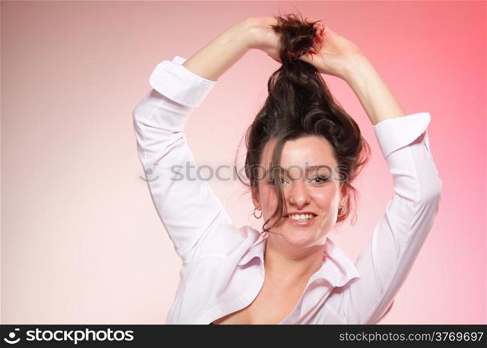 portrait of attractive caucasian smiling woman brunette holding her long healthy hair pink background studio shot