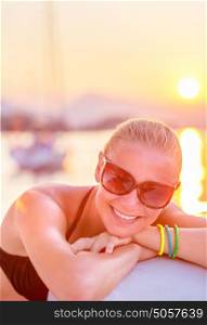 Portrait of attractive cheerful girl having fun in sea cruise, enjoying bright yellow sunset light, luxury summer adventure concept