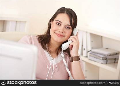 Portrait of attractive executive woman at office on phone