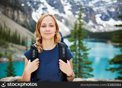 Portrait of attractive female hiker with her backpack against scenic view