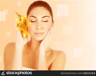 Portrait of attractive female with closed eyes and yellow lily flower isolated on beige background, luxury spa salon, beauty treatment, pampering concept&#xA;