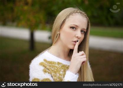 Portrait of attractive girl with finger on lips, concept of student show quiet, silence, secret gesture, young pretty blonde woman