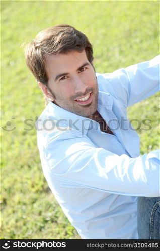 Portrait of attractive man sitting in park