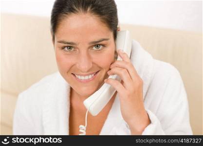 Portrait of attractive mid-aged woman speaking on phone wear bathrobe