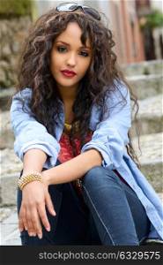 Portrait of attractive mixed woman in urban background wearing casual clothes