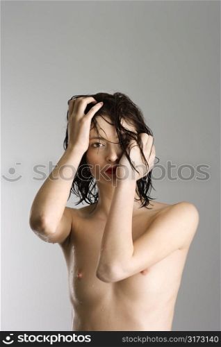 Portrait of attractive nude Caucasian redhead young woman with wet hair.