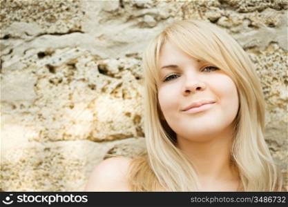 Portrait of attractive smiling girl against stones background