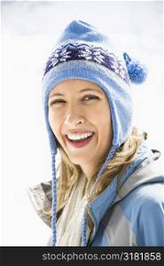 Portrait of attractive smiling mid adult Caucasian blond woman wearing blue ski cap looking at viewer.