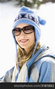 Portrait of attractive smiling mid adult Caucasian blond woman wearing blue ski cap and sunglasses looking at viewer.